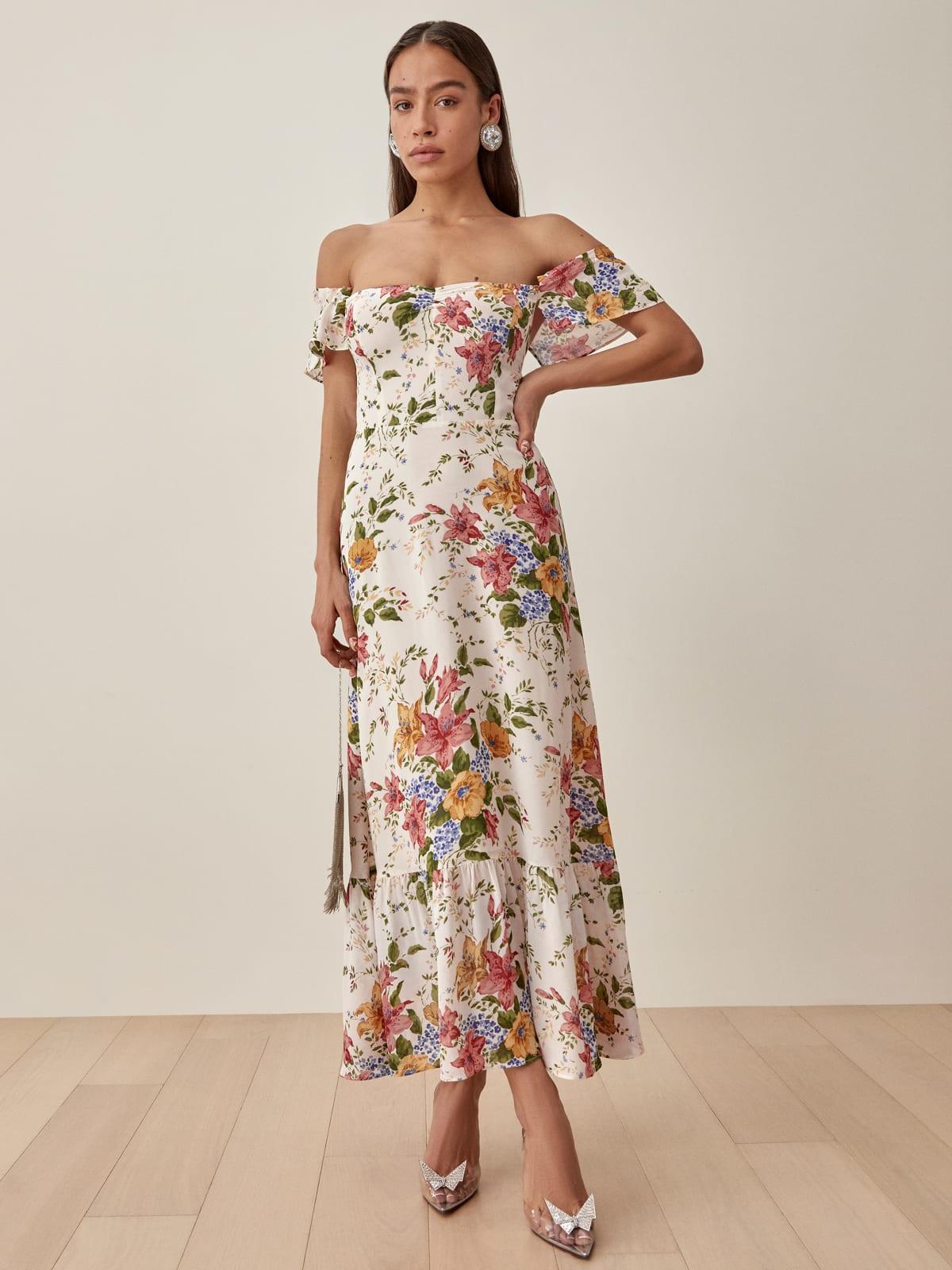 Image of a model with her hand on her hip wearing an off-the-shoulder dress in a floral print