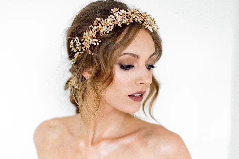 Bride with a loose updo, smoky eye wedding makeup, a dark lip and a crystal adorned headband