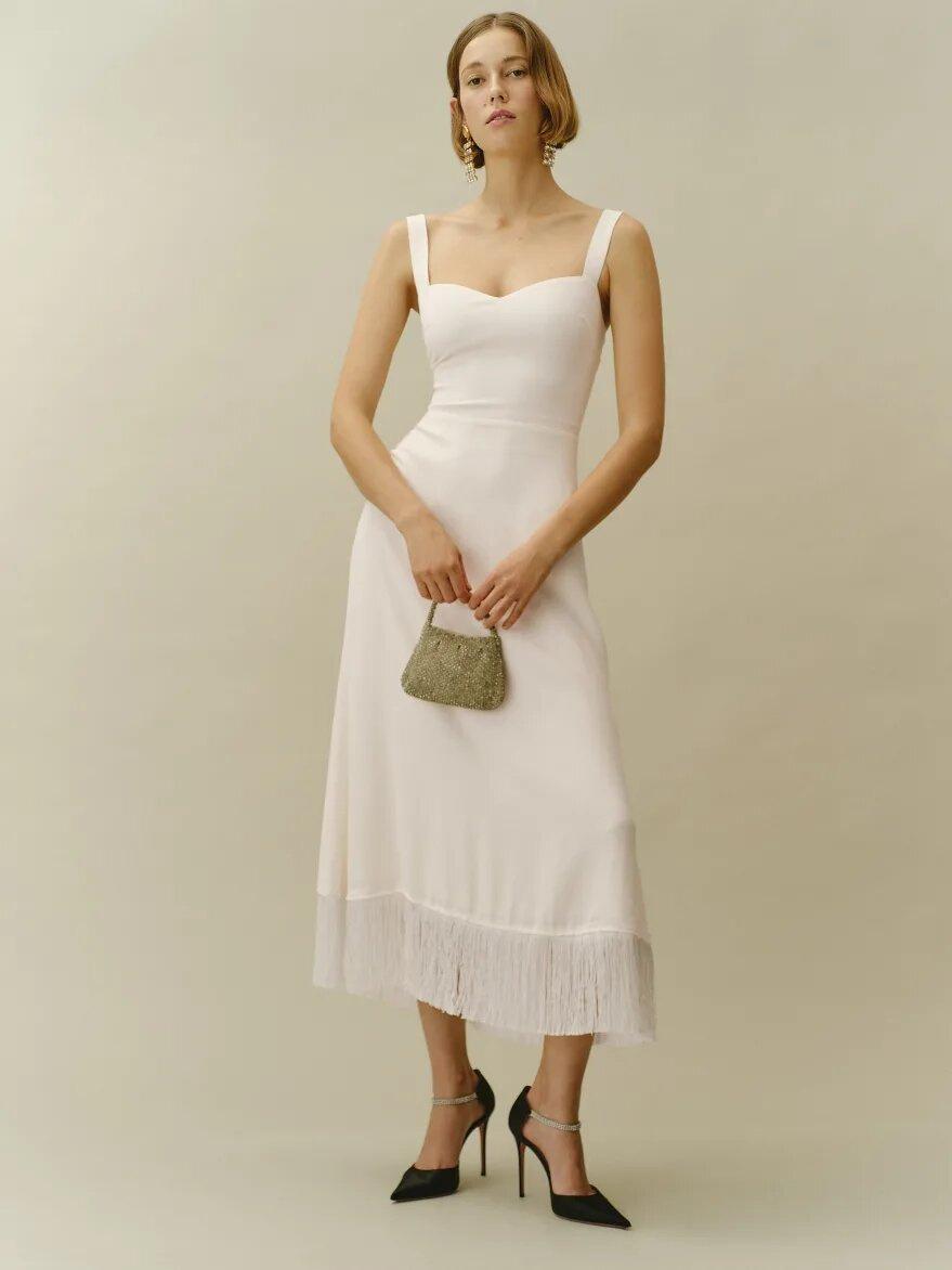 Model wearing a simple white wedding dress