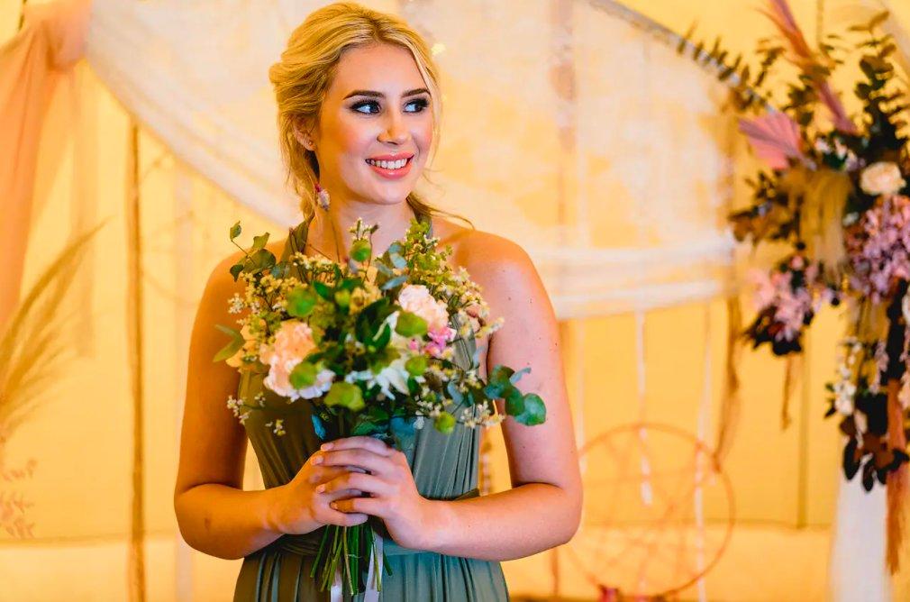 Bridesmaid with coral lip holding a bouquet