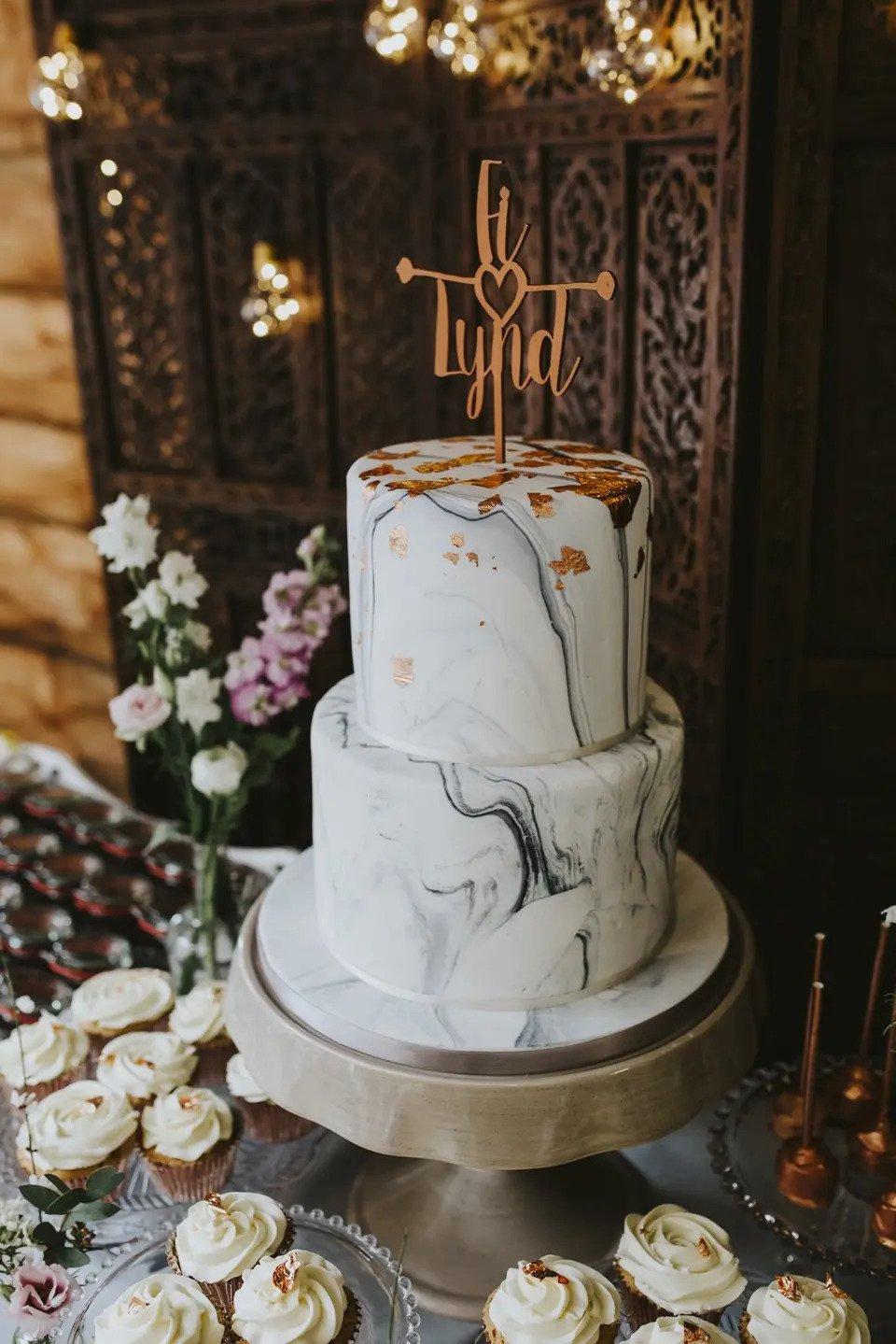 marble wedding cake with two tiers and copper golden leaf design at the top