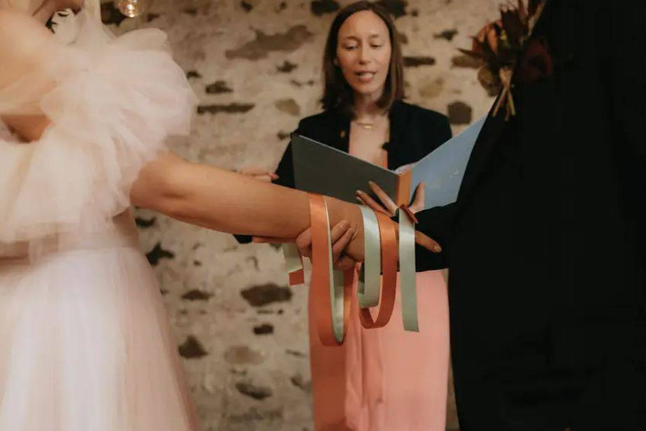 Couple during Irish wedding tradition hand fastening ceremony