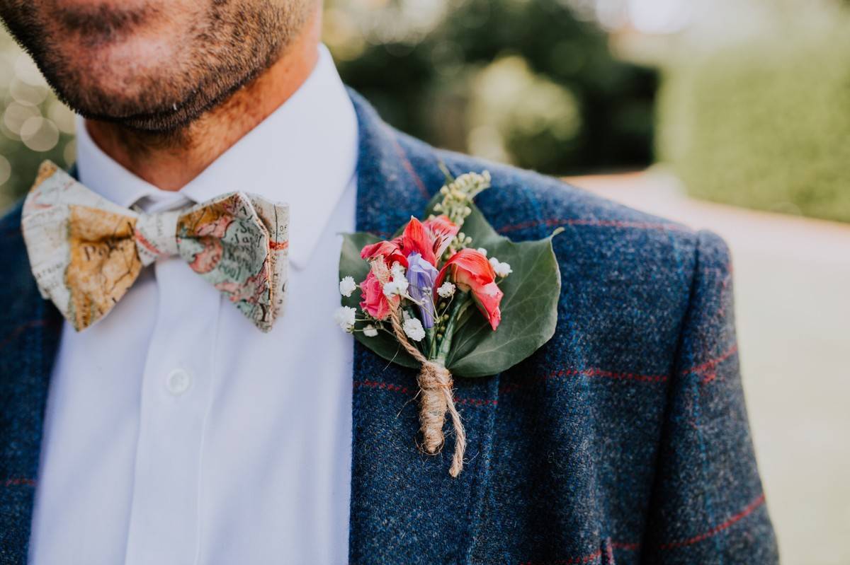 Stylish Groom In Blue Suit With Bow Tie And Boutonniere With Pink