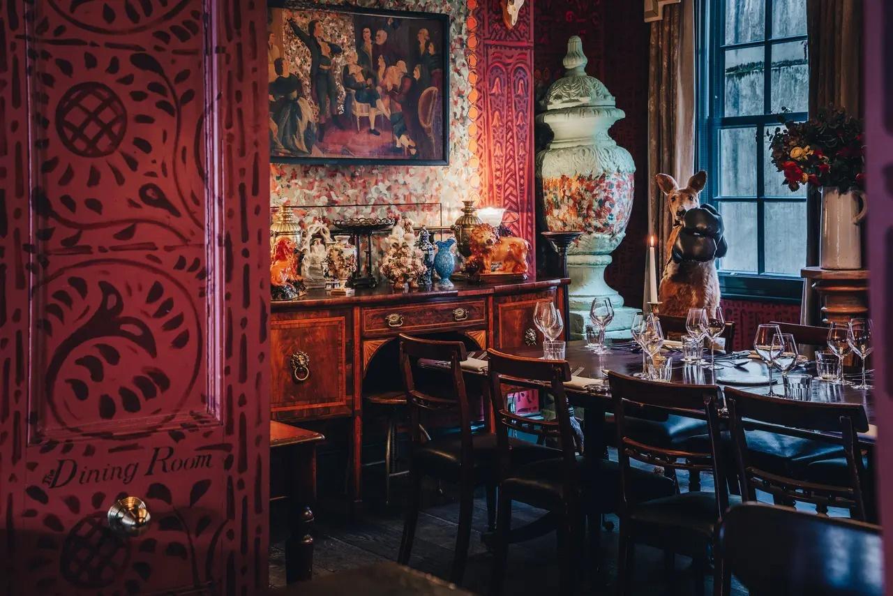 An eclectic private dining room filled with quirky colourful wallpaper and decor