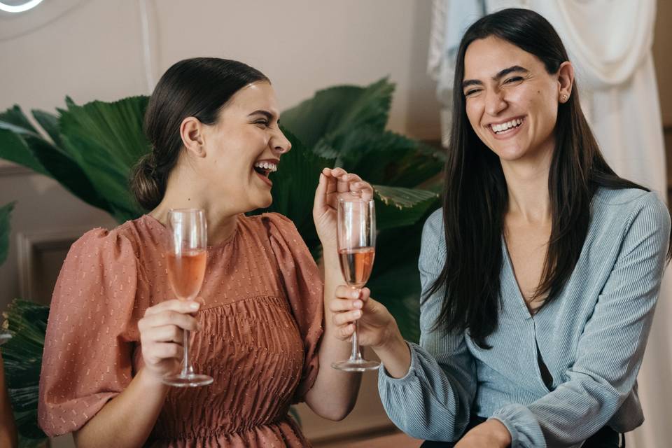 Bridesmaid and friend drinking wine together