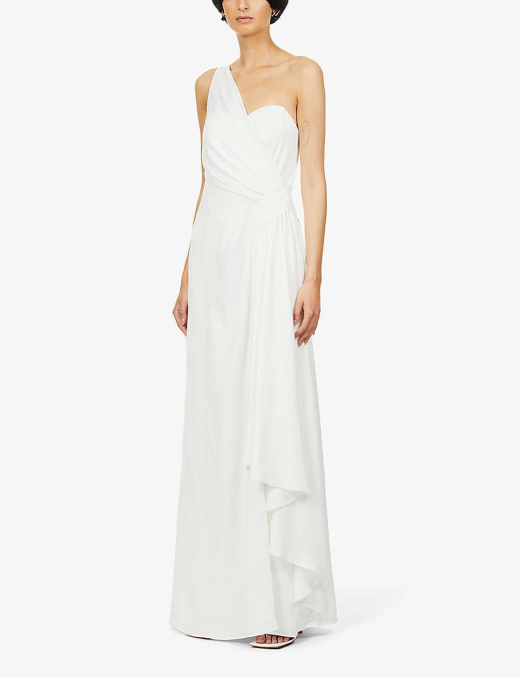 Olive skinned woman with short dark hair wearing a draped white one shoulder wedding dress