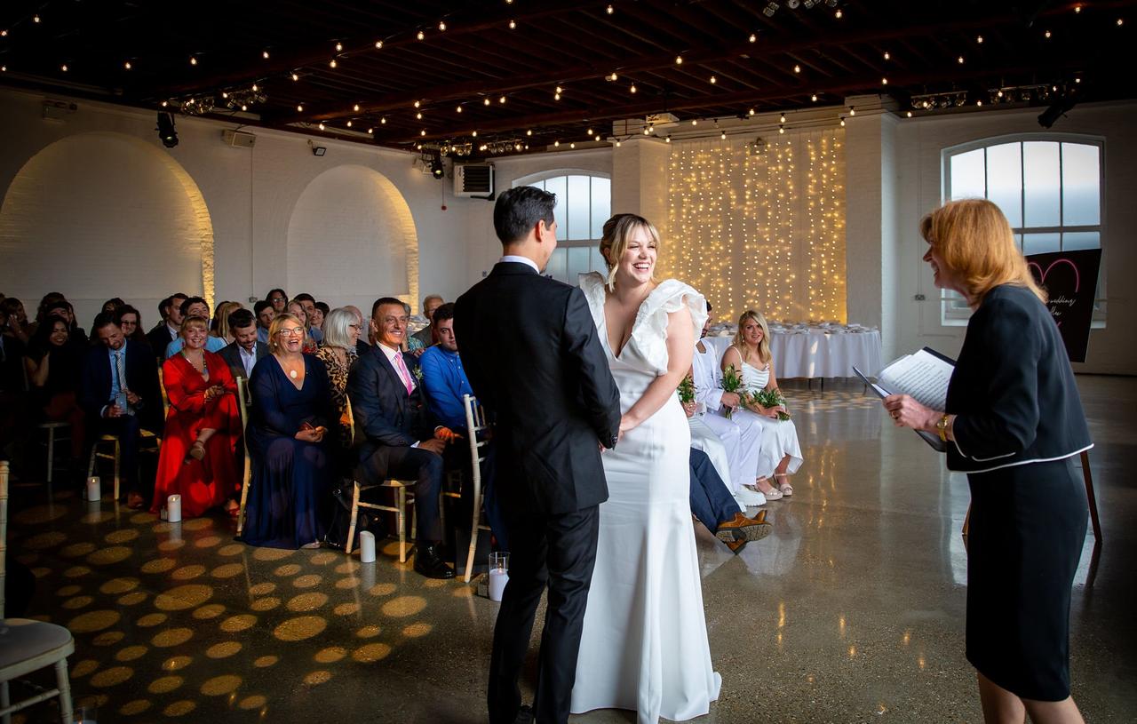 A bride and groom hold hands at the altar
