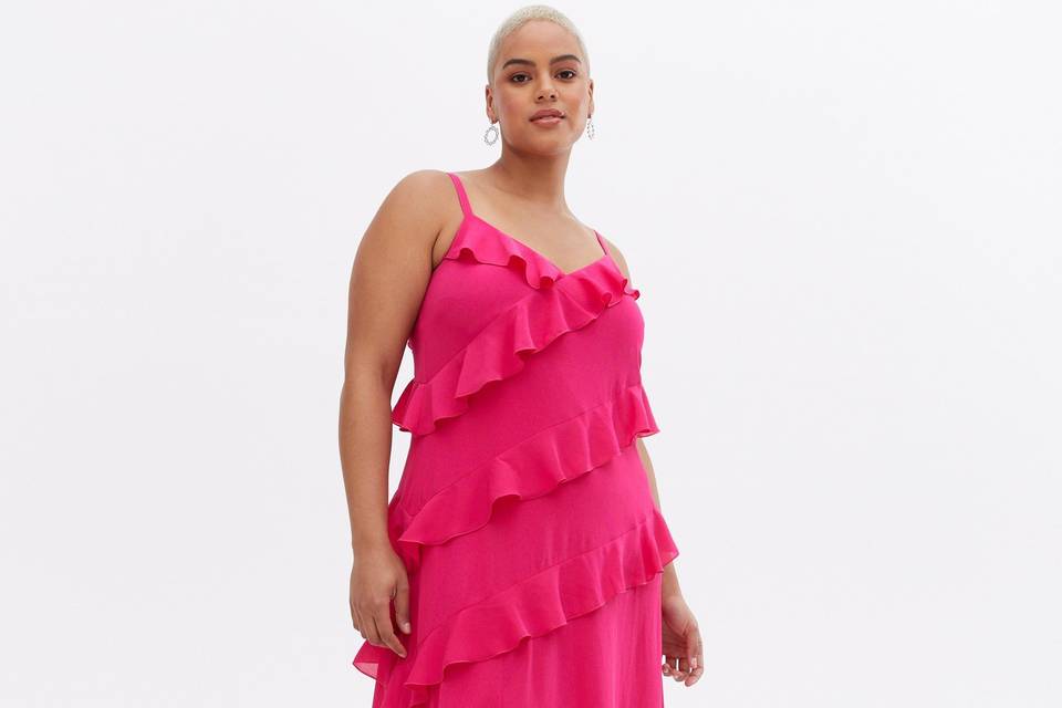 Model wearing a pink ruffle wedding guest dress