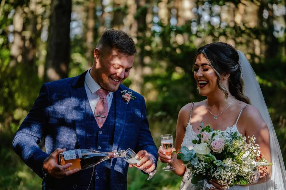 Durham wedding couple drinking champagne - the groom is pouring it into two glasses