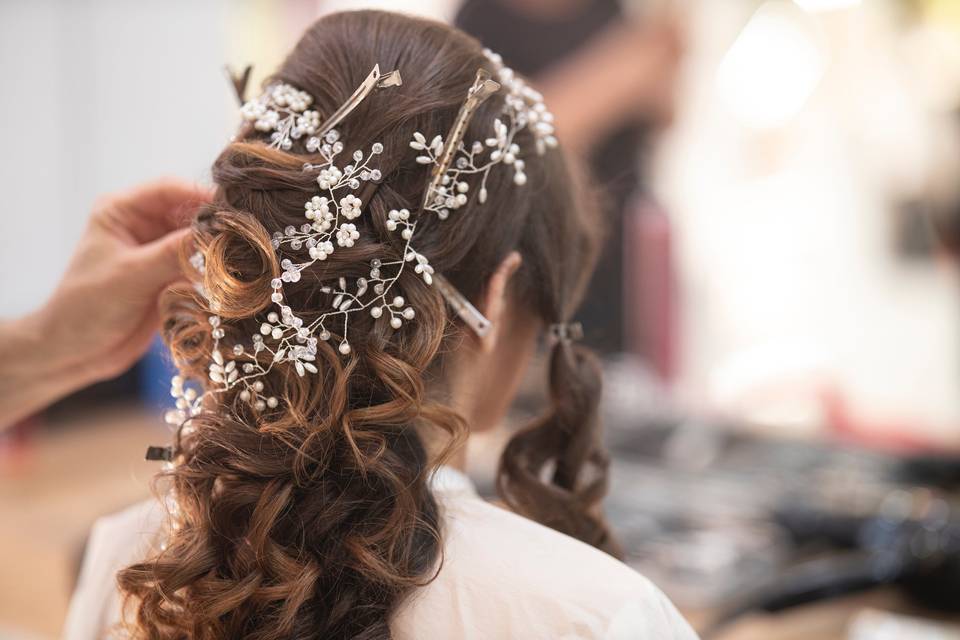 Bride with dark hair being styled at a wedding hair trial with a pearly hair vine