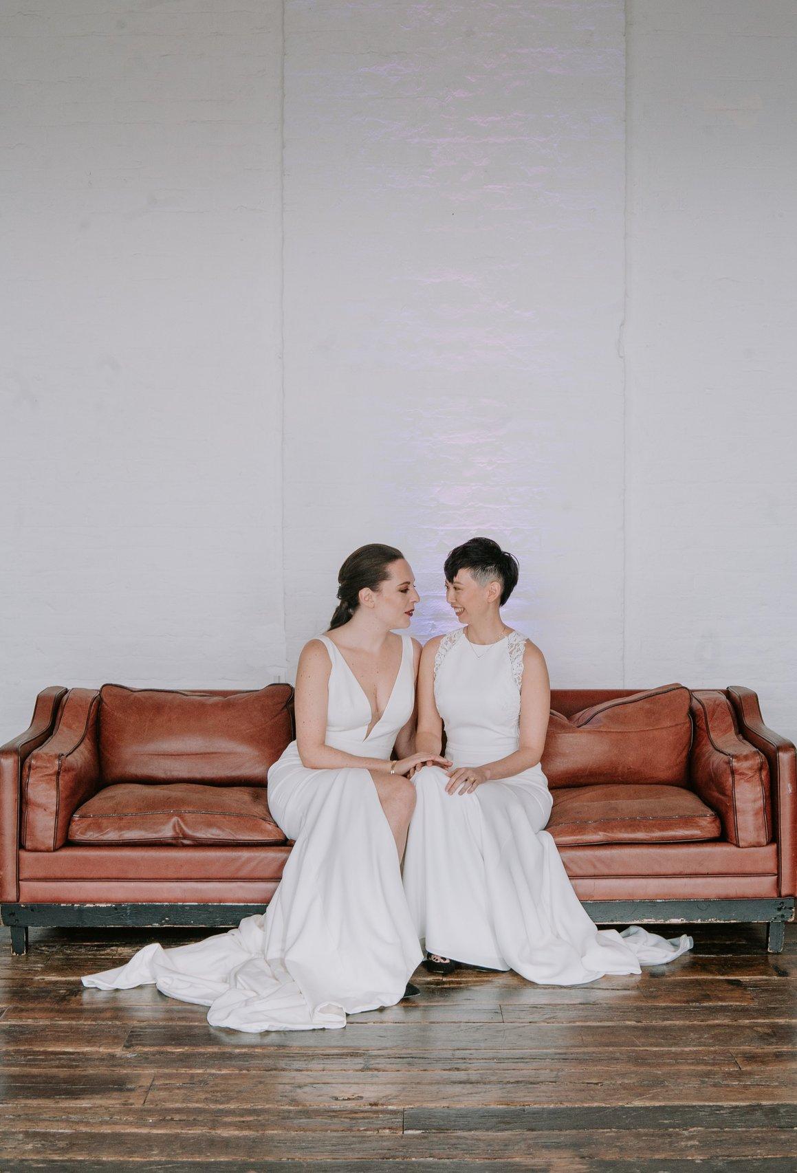 The brides sitting facing each other on a sofa