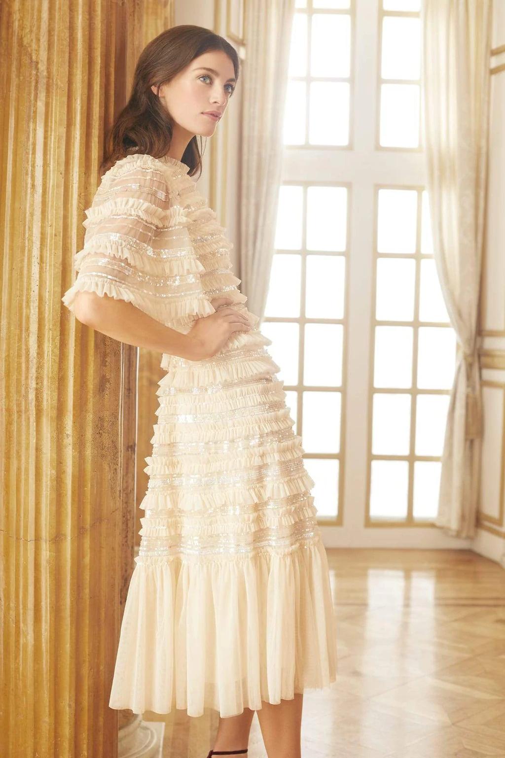 Model wearing a ruffle tea length wedding dress