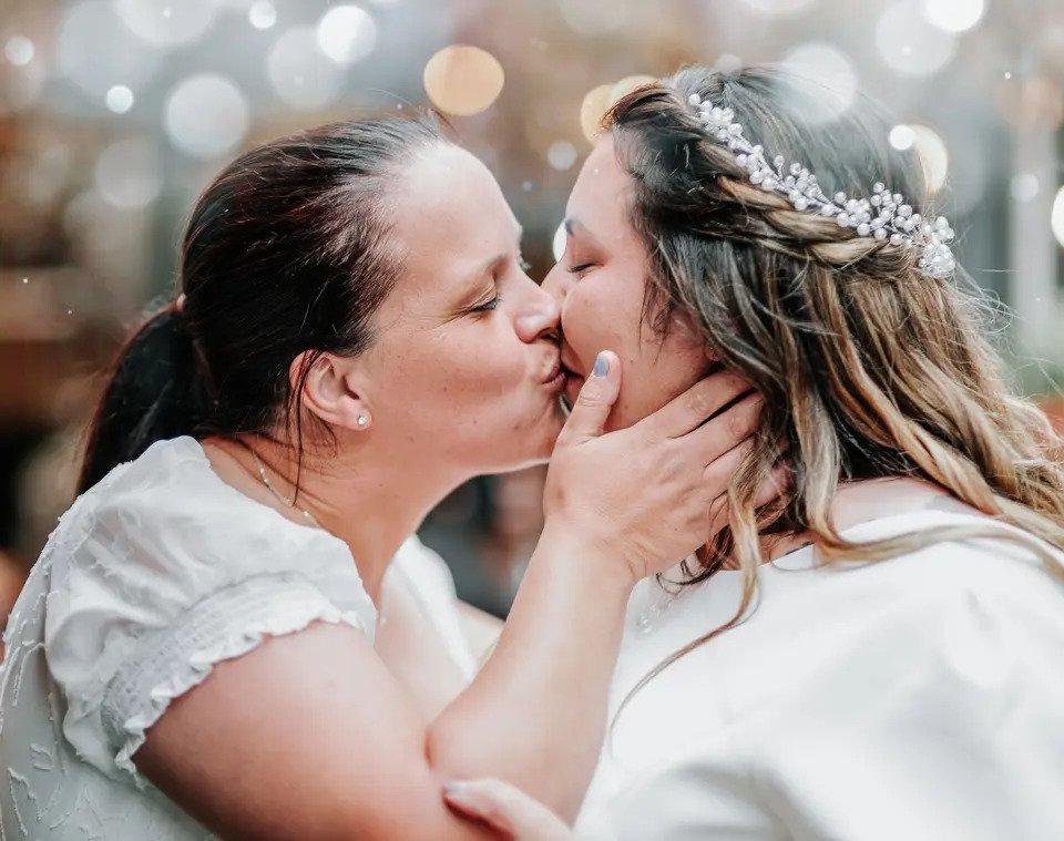 Close up shot of two brides kissing