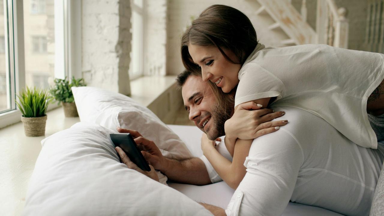 Man and woman lying in bed playing truth or dare