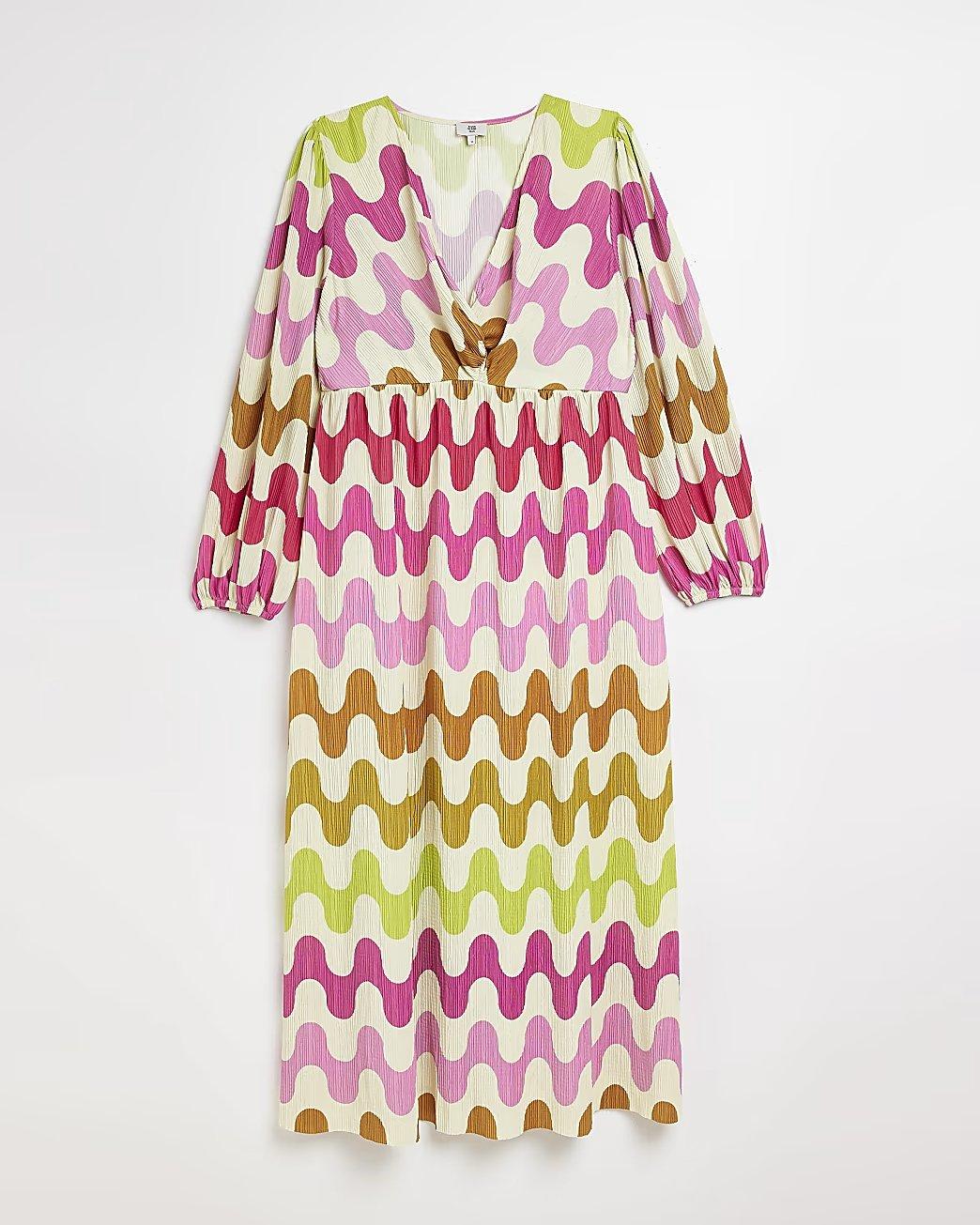 Plus size autumn wedding guest dress with plisse fabric and a retro 70s swirl print in pink, green and orange