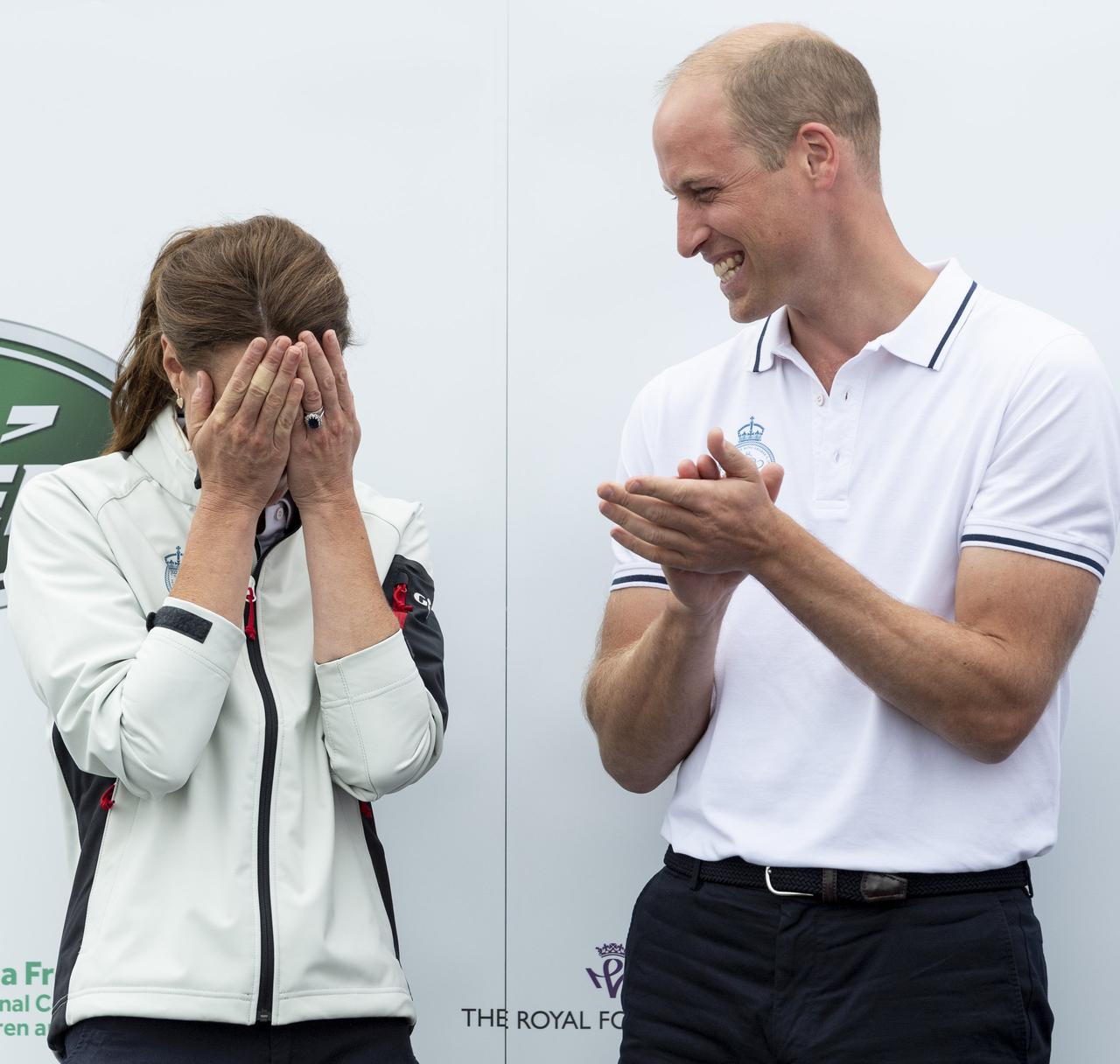 Kate Middleton holds her hands to her face as Prince William laughs