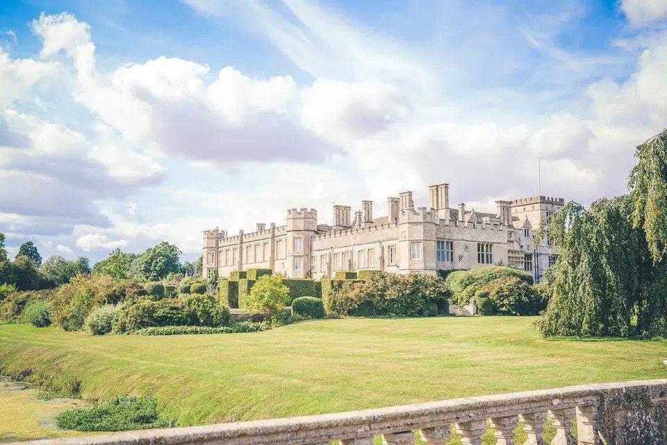 Castle wedding venue taken from the grounds with verdant lawns and trees
