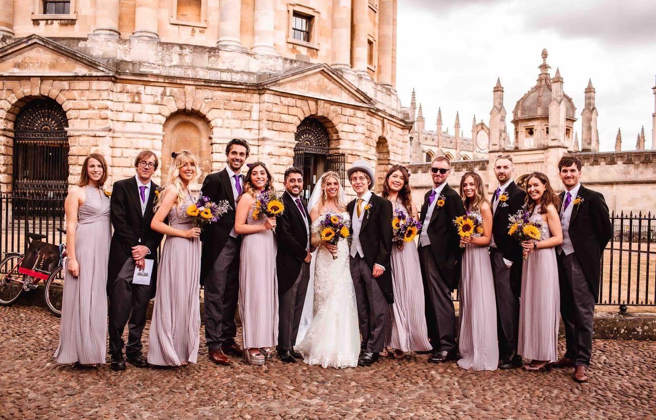 The bride, groom and their groomsfolk pose for a photo in Oxford