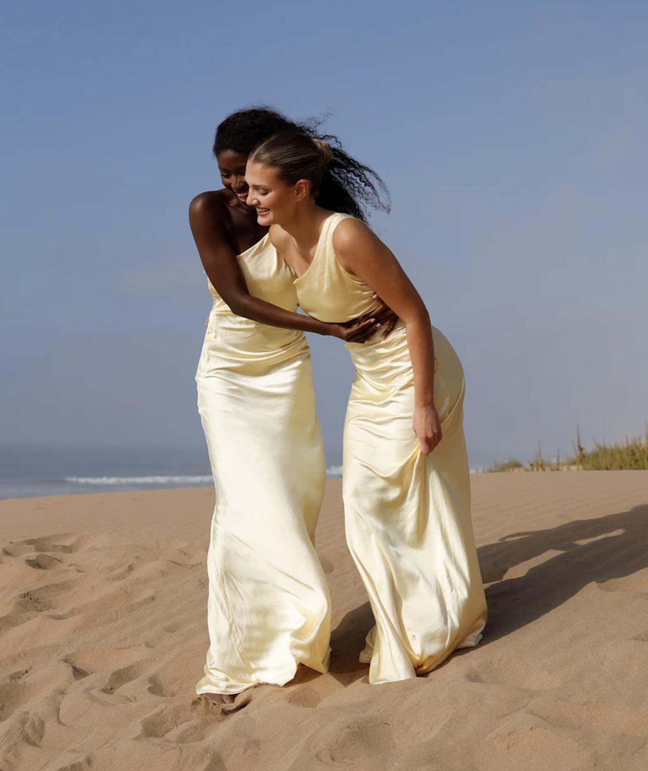 two models in butter yellow bridesmaid dresses on the beach