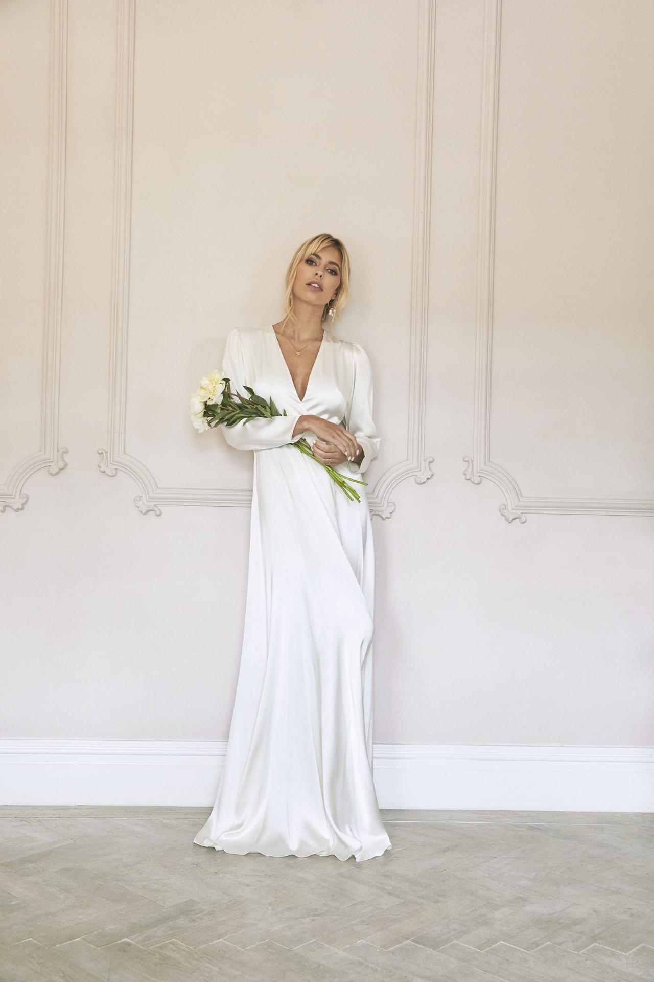Model wearing a wrap long sleeved wedding dress