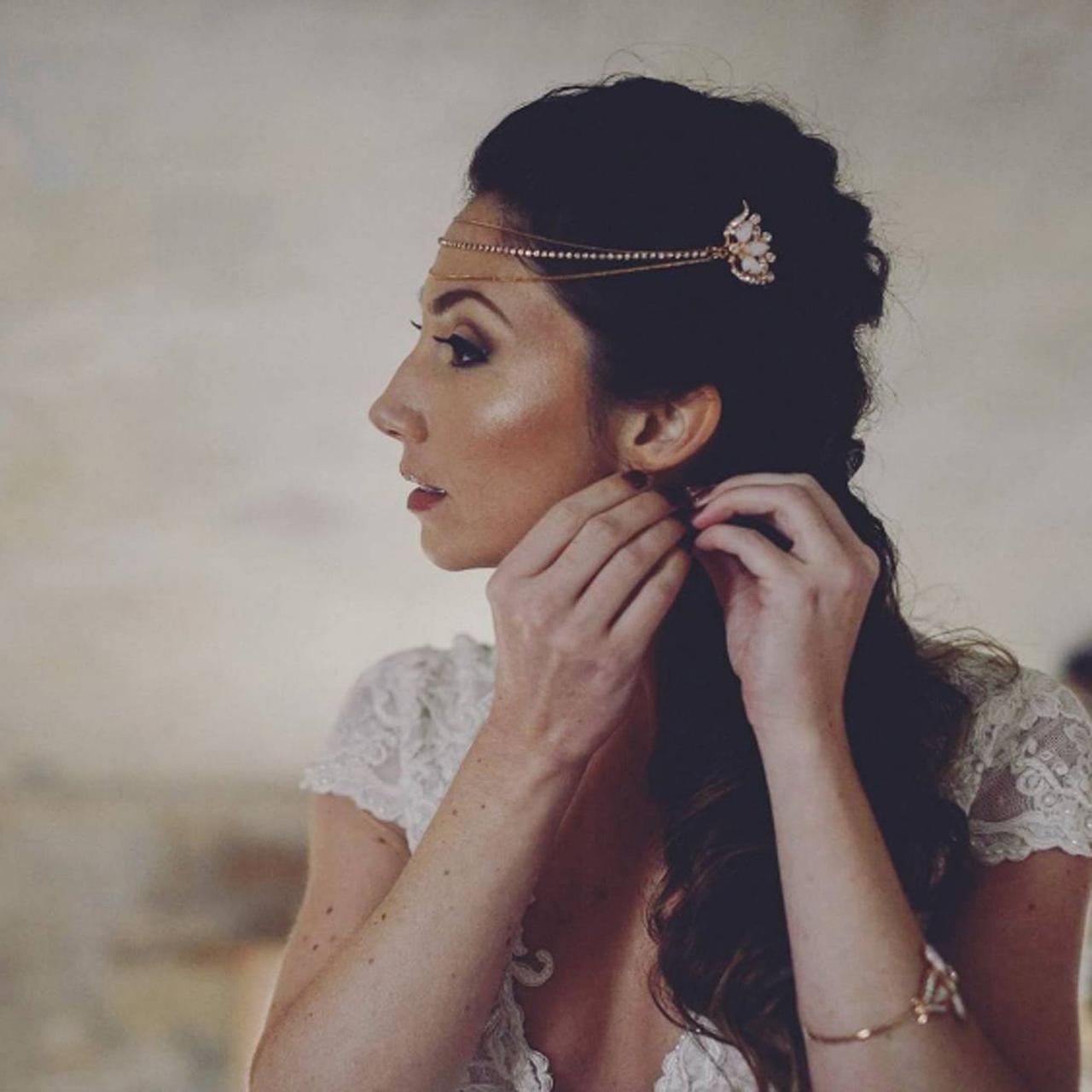 A rose gold head band with three chains worn across the forehead and embellished fasteners