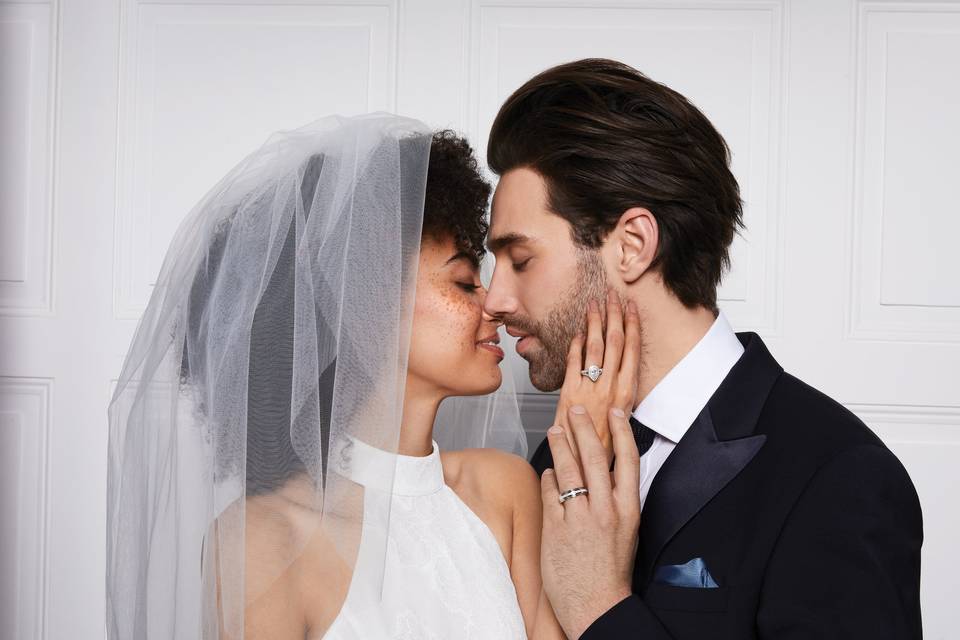 Bride wearing veil touching groom's face