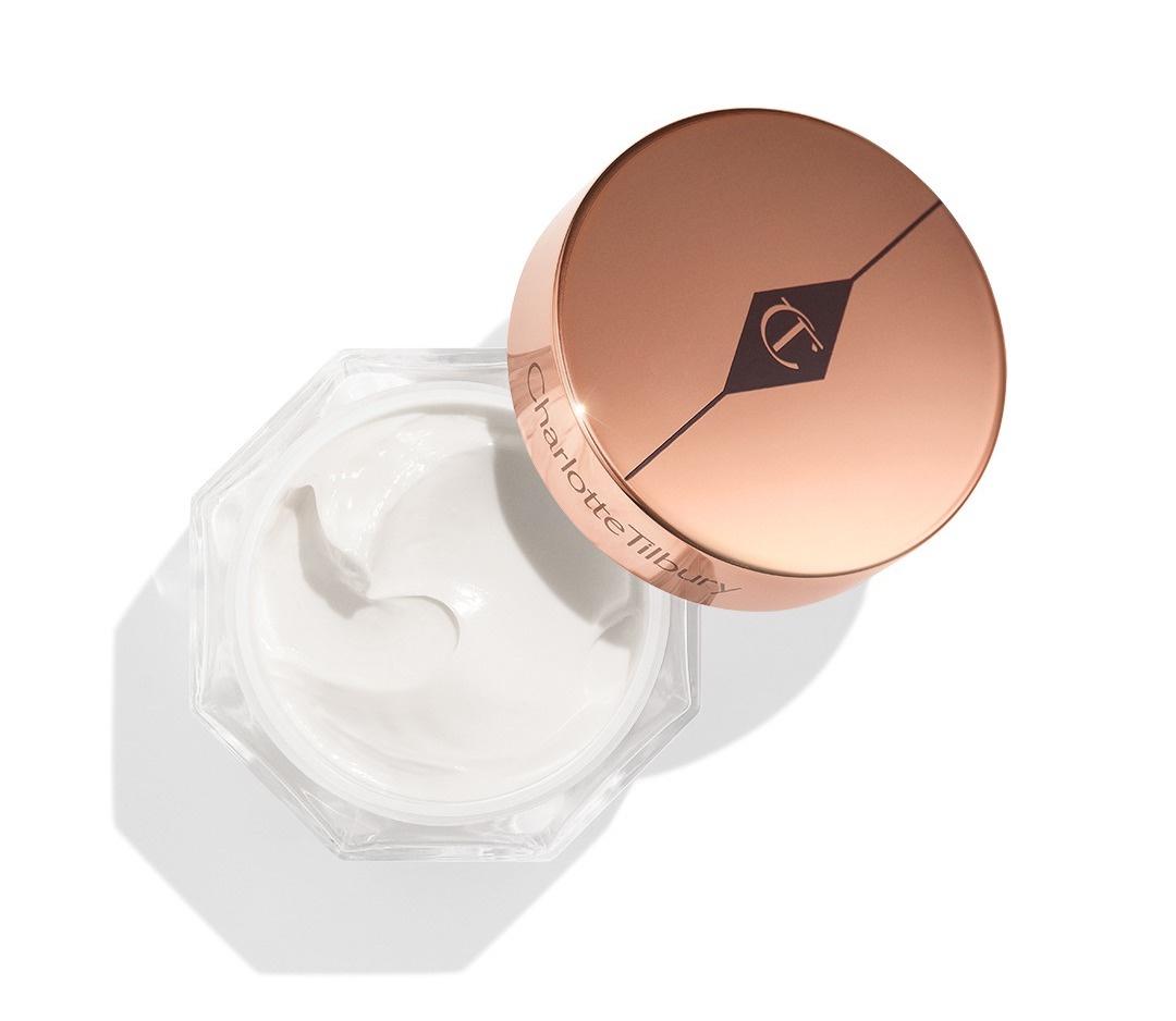 An open jar of face cream with gold lid.