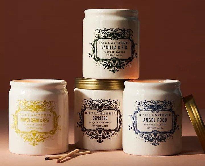 A stack of four candles in vintage style pots with gold lids