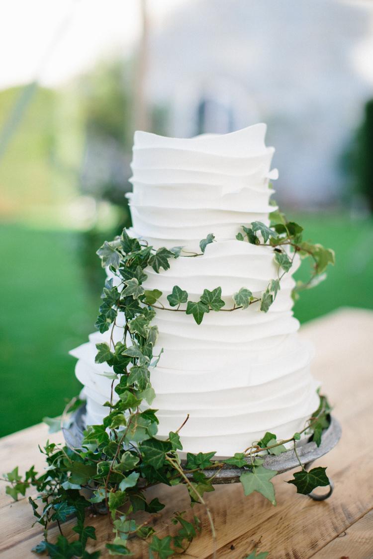 Rustic wedding cake with white icing and ivy