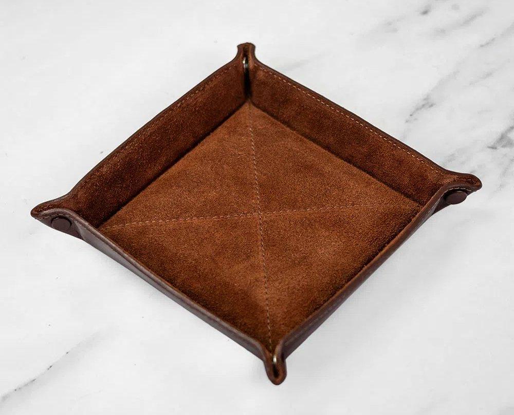 A brown leather square-shaped coin tray.