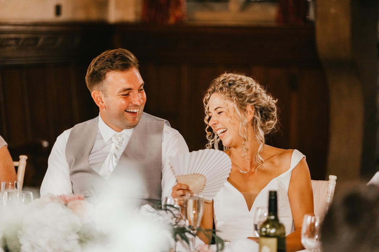 The bride and groom laugh at the speeches