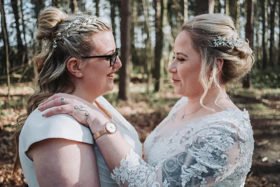 Two brides looking at each other and smiling as they hold each other