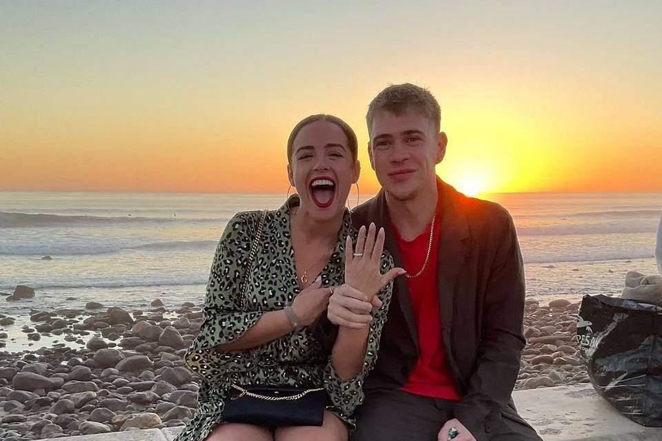 Actress Georgia May Foote sitting next to fiance Kris Evans at sunset, showing off her engagement ring