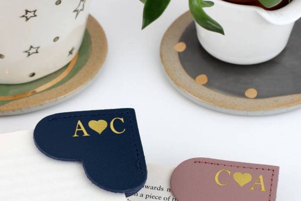 Two open books featuring a monogrammed heart-shaped corner bookmark on each page.