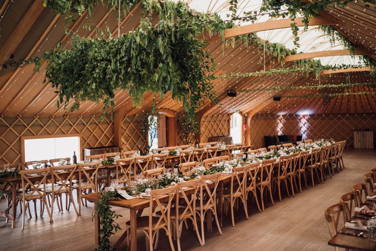 Inside wooden marquee with long tables and elegant foliage at Thorpe Garden, Staffordshire