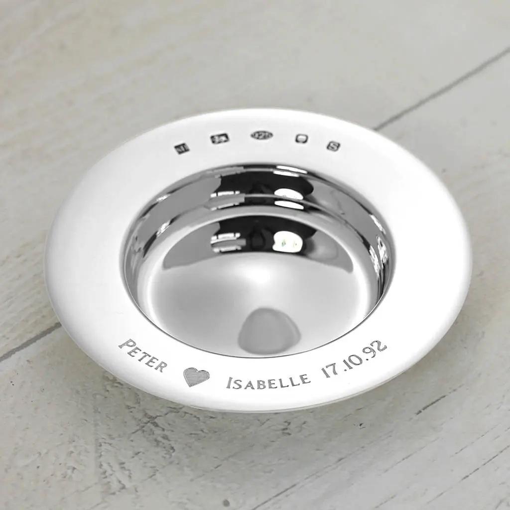 A solid silver dish engraved with names and a love heart symbol.