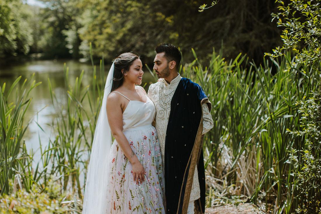 Couple standing by the lake at Northamptonshire wedding venue Hinwick Hall