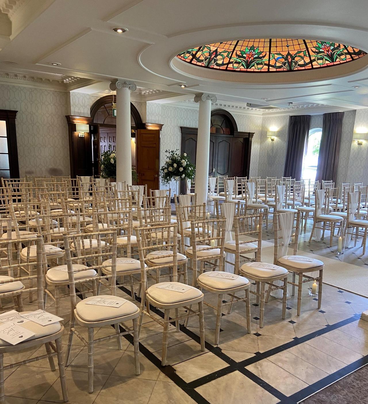 Interior of a grand hall in a hotel set up for a wedding ceremony.