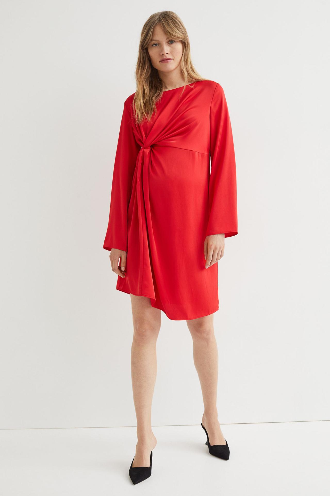 Model wearing a draped satin short red maternity bridesmaid dress