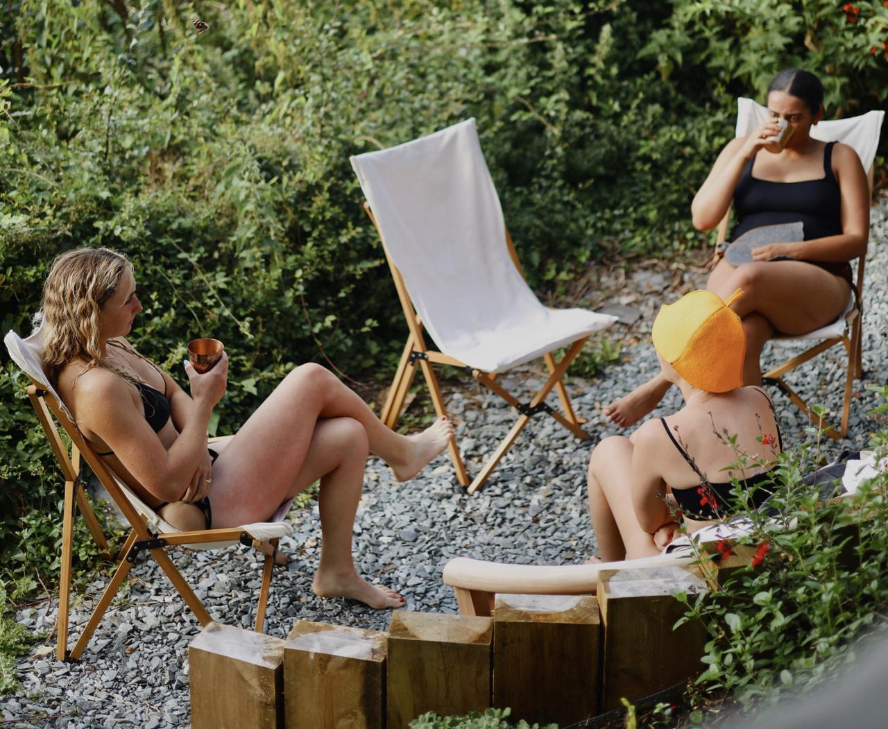 group of girls drinking tea overlooking the sea during a sauna session at Polhawn Fort