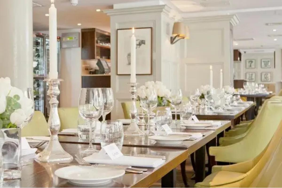  a smart dining room in a small london wedding venue set up for a wedding breakfast with dining tables and yellow chairs