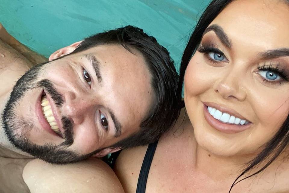 Scarlett Moffatt and boyfriend Scott Dobinson smiling for a selfie in a pool at a spa