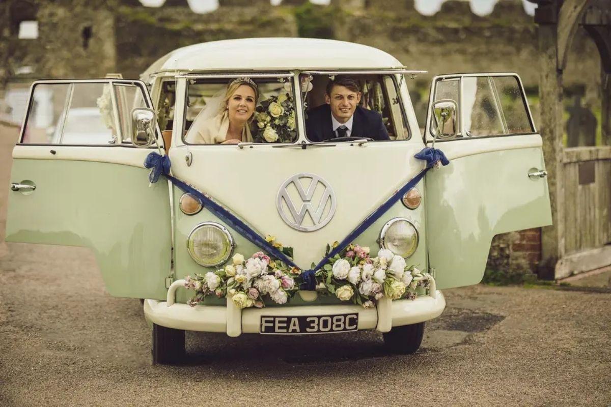 a bride and groom smile and pose inside a vintage sage green VW camper van