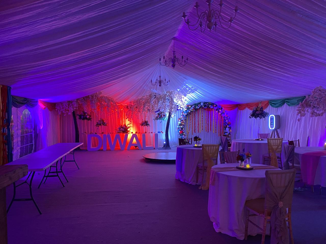 a large marquee decorated for diwali with a light up, large white letter sign spelling diwali 