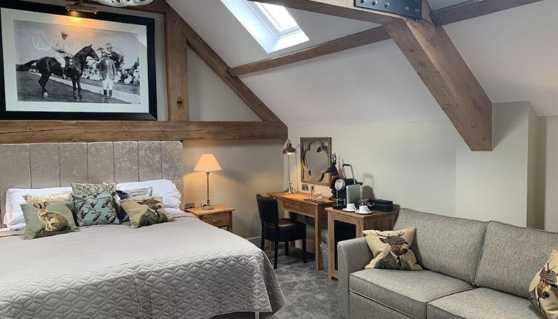 a countryside style bedroom in The Wheatsheaf hotel in Cheshire with wooden beams and soft decor