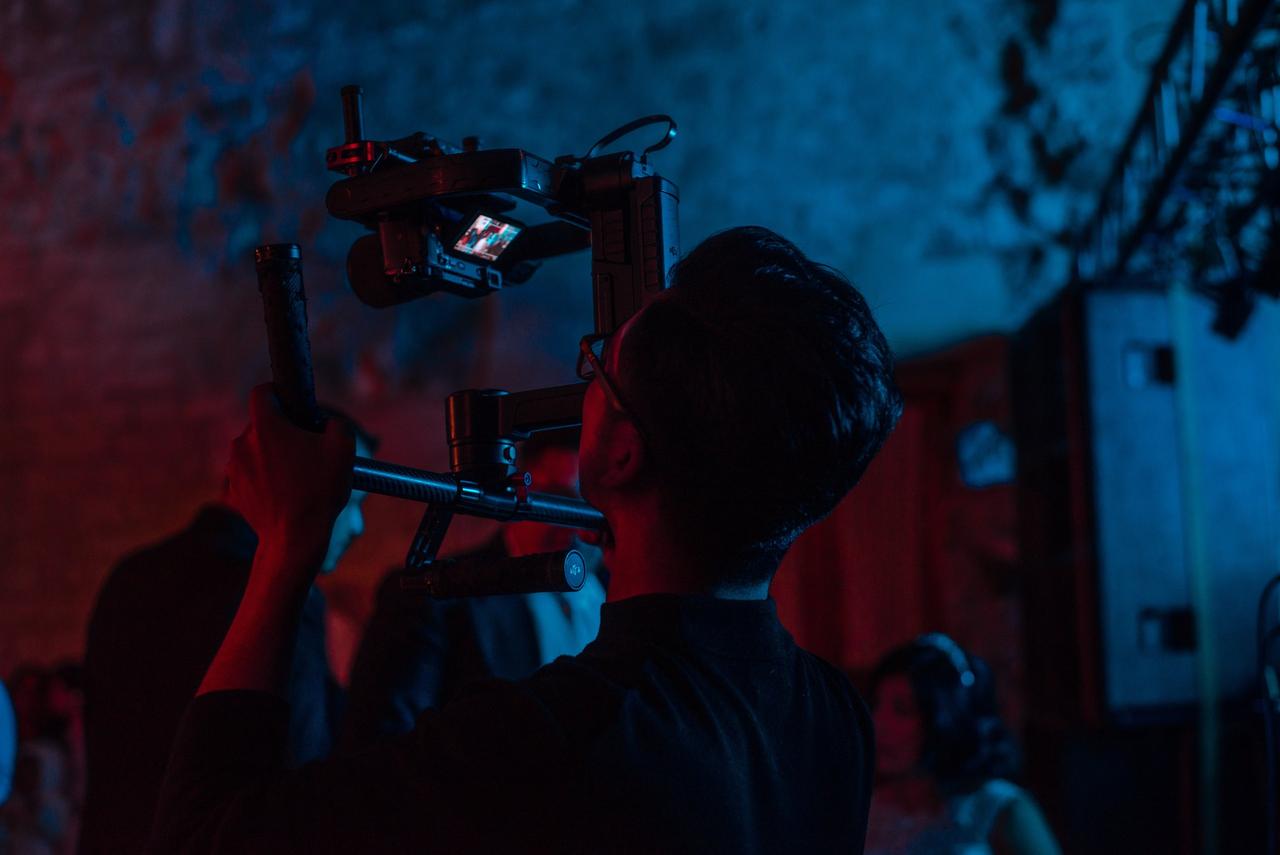Male videographer filming the dance floor at a wedding reception