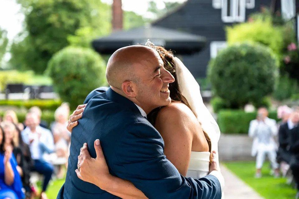 Bride and groom hug at an outdoor wedding ceremon