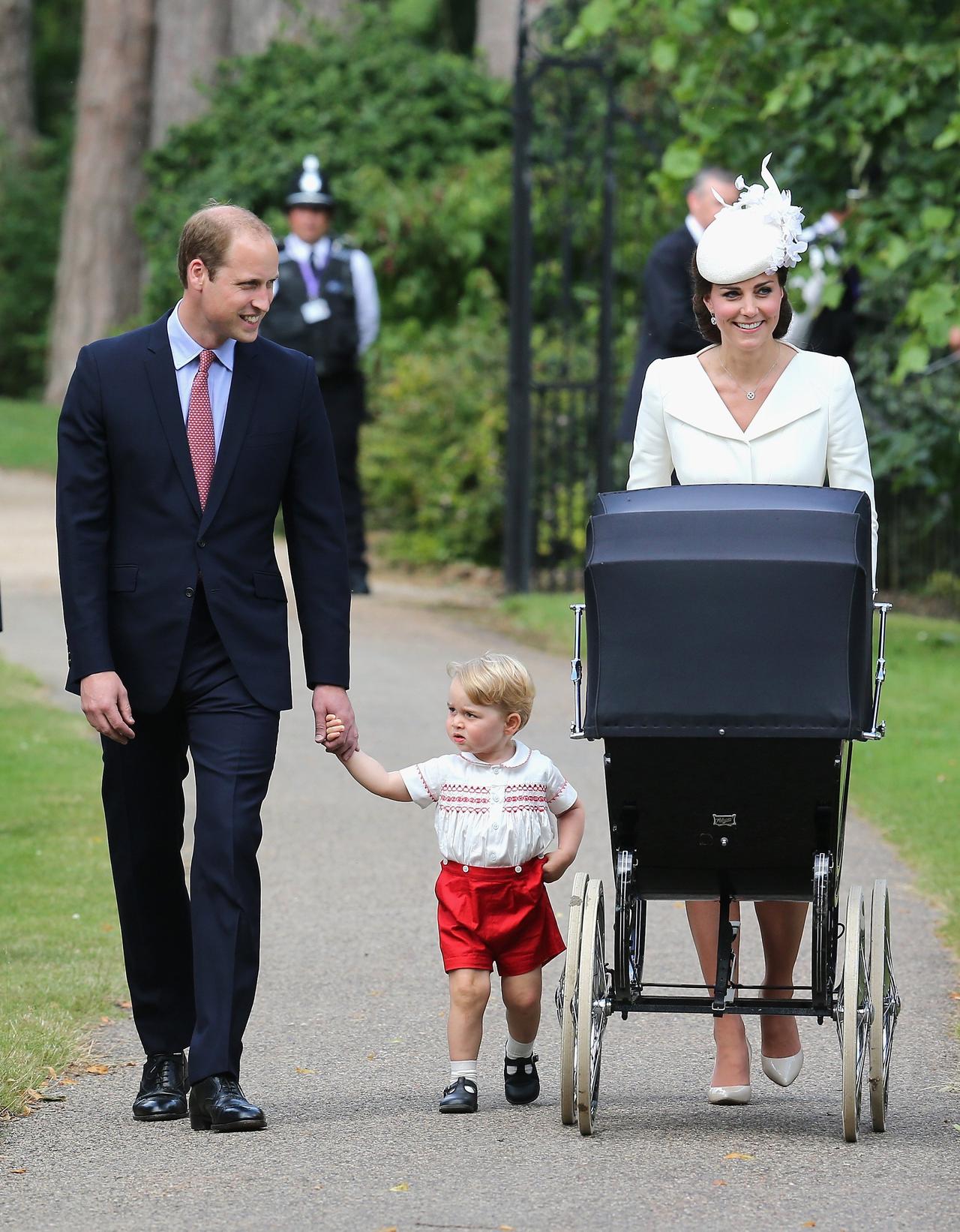 Kate Middleton and Prince William walk along with George while they push Charlotte in a pram