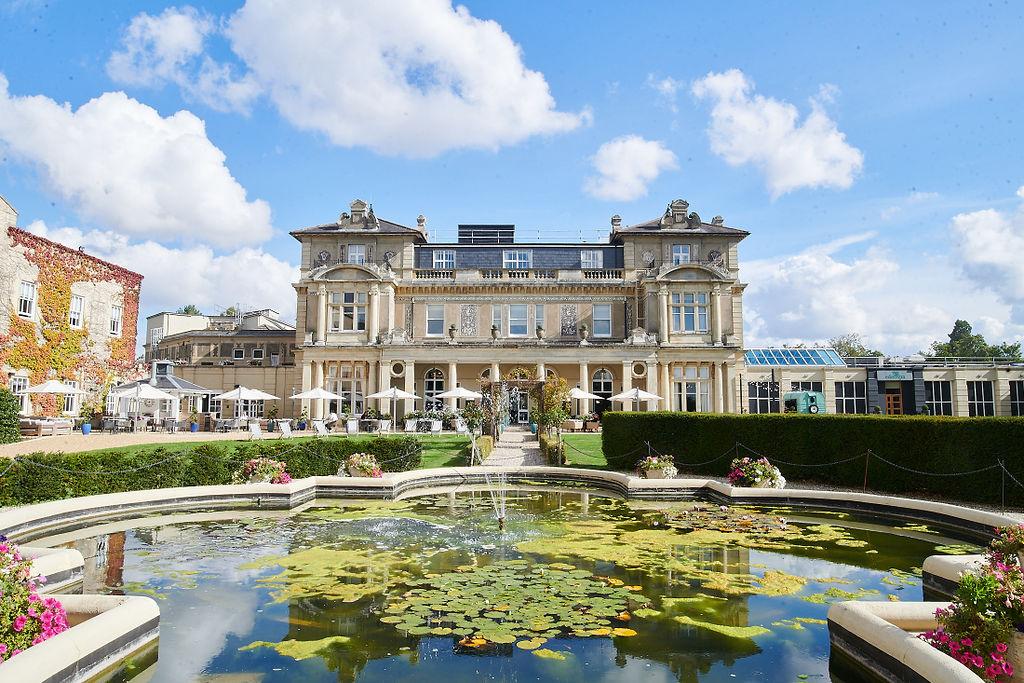Exterior of the manor house style hotel wedding venue with a lily pad covered ornamental pond in the foreground