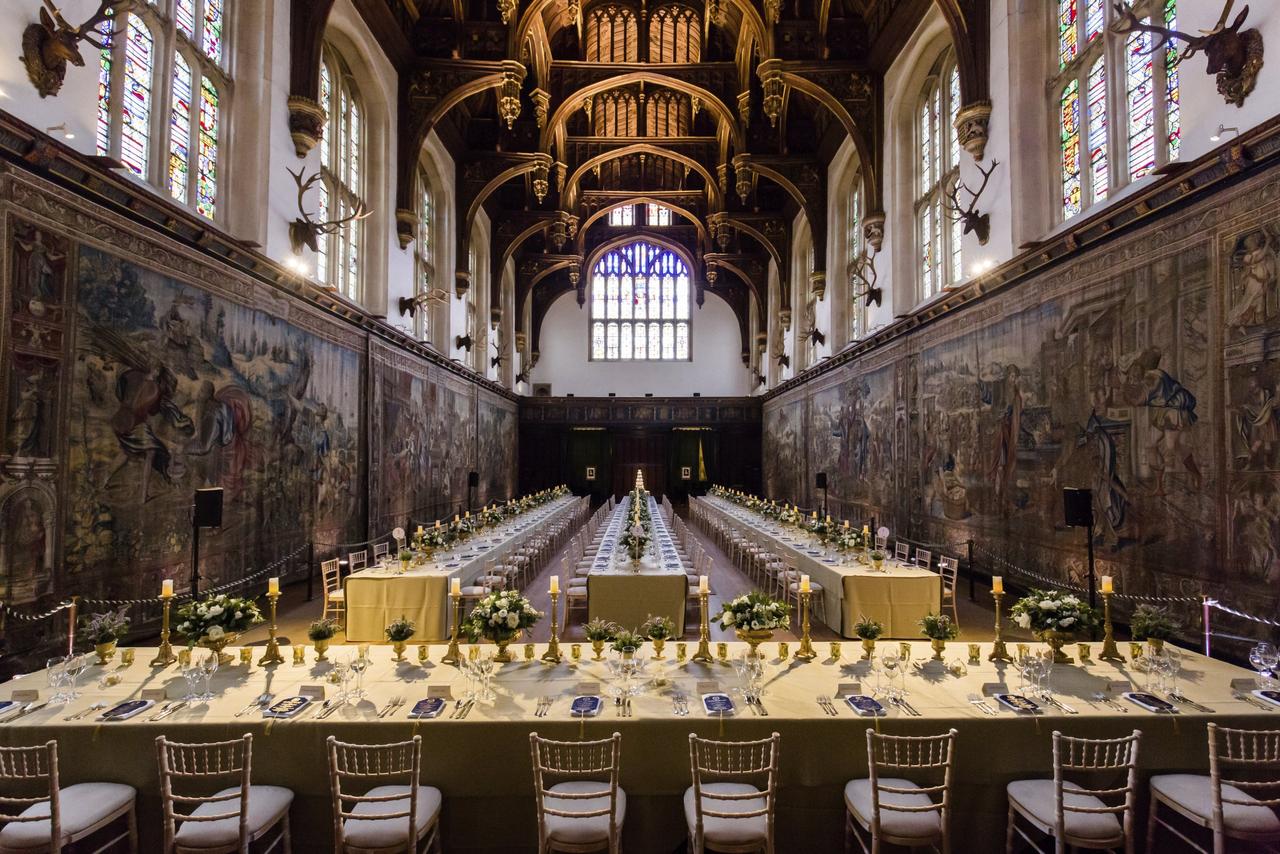 a grand, gothic dining hall of Hampton Court Palace, lined with tables and decorated with haunted, ancient artefacts